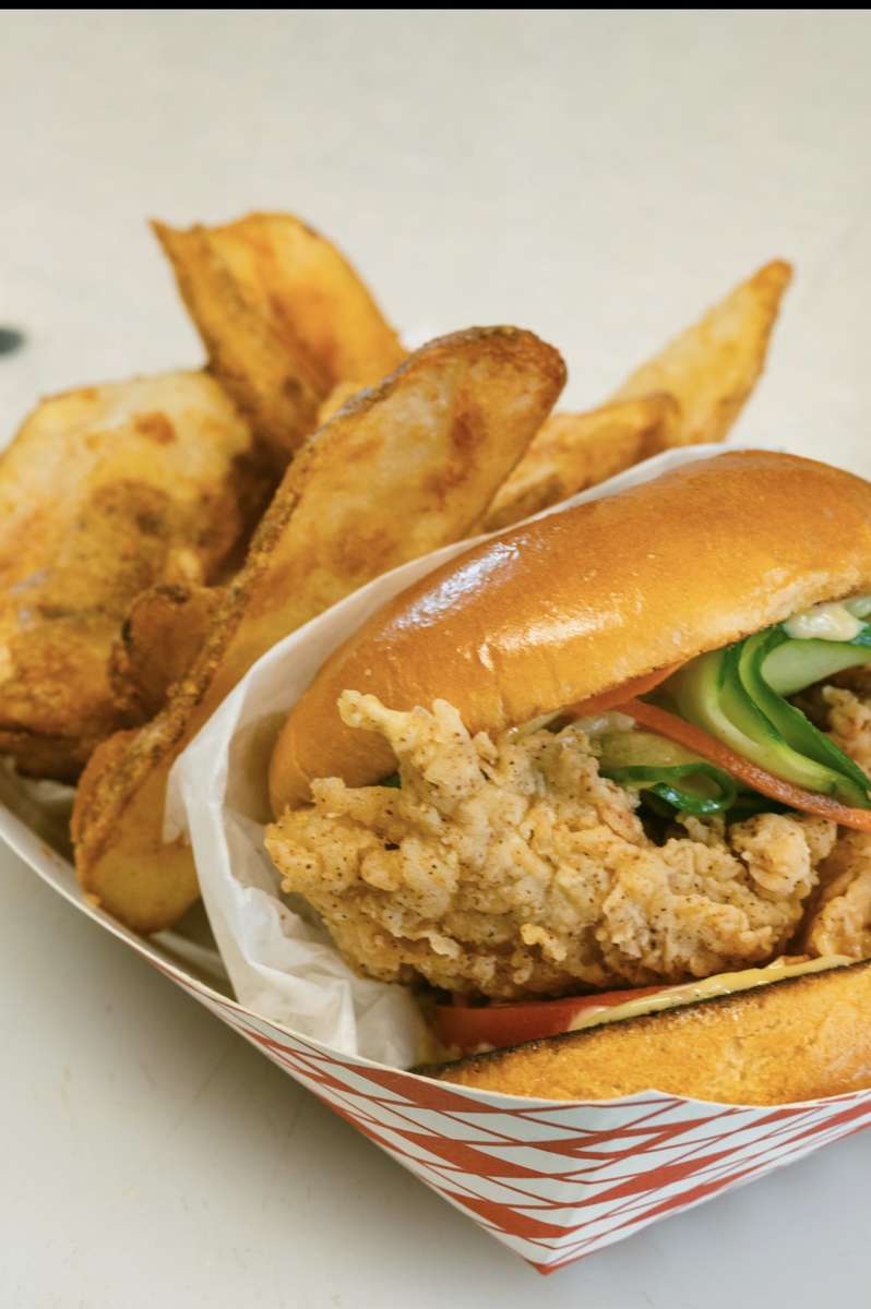 Lobster burger on a brioche bun with seasoned potato wedges